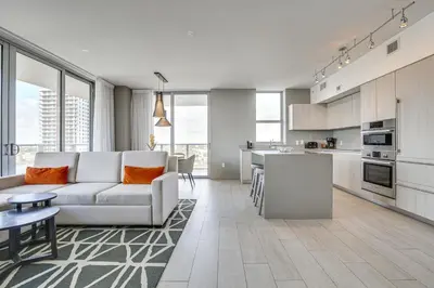 a living room with a couch and a kitchen at Walk to Hollywood Beach Upscale 16th-Floor Condo in Hollywood