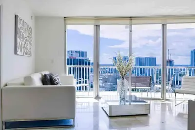 a living room with a white couch and a large window at Beautiful apartment Miami, FL in Miami