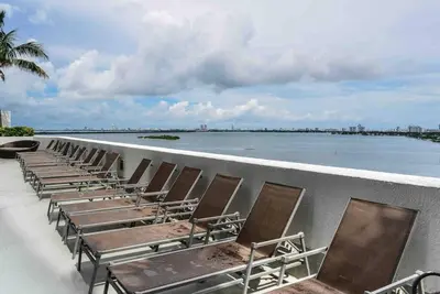 a row of chairs sitting on a wall next to the water at Beautiful apartment Miami, FL in Miami