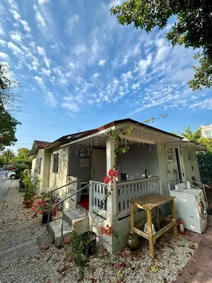 a small green house with a porch and a table at Deluxe Room in best location Miami in a 2 Bedrooms Unit - Parking, Laundry and Luggage Storage in Miami