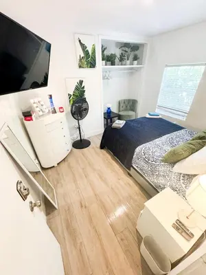 a bedroom with a bed and a flat screen tv at House 2 Bedrooms plus CouchBed Best Location MIami Private Parking, Laundry, Storage for Luggage in Miami