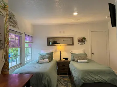 a room with two beds and a table and a window at House 2 Bedrooms plus CouchBed Best Location MIami Private Parking, Laundry, Storage for Luggage in Miami