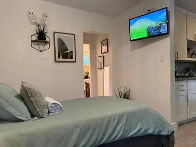a bedroom with a bed with a flat screen tv on the wall at House 2 Bedrooms plus CouchBed Best Location MIami Private Parking, Laundry, Storage for Luggage in Miami