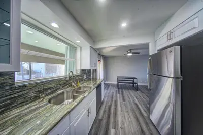 a kitchen with a sink and a refrigerator at Mahalo Isles Apartments by Rocketstay in Fort Lauderdale