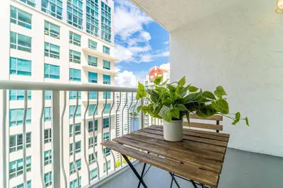 a wooden bench with a potted plant on a balcony at Lovely Studio in brickell -2 beds and Free parking in Miami