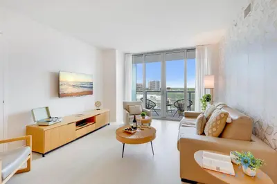 a living room with a couch and a desk at Beachwalk Resort Prime Location Balcony Gym in Hallandale Beach