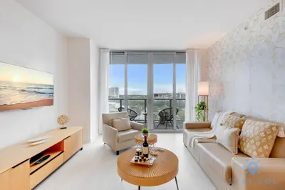 a living room with a couch and a table at Beachwalk Resort Prime Location Balcony Gym in Hallandale Beach