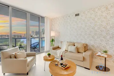 a living room with a couch and a table at Beachwalk Resort Prime Location Balcony Gym in Hallandale Beach