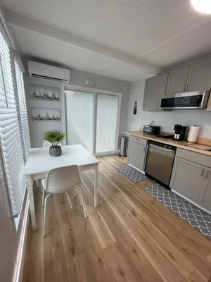 a kitchen with a table and a white table and chairs at Unique Houseboat Modern and New in Fort Lauderdale
