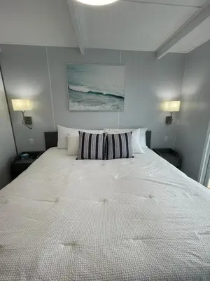 a large white bed with a striped pillow on it at Unique Houseboat Modern and New in Fort Lauderdale