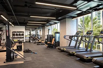 a gym with treadmills and machines in a room at High Style Living in the Heart of Miami in Miami