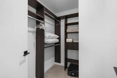 a walk in closet with wooden shelves and towels at High Style Living in the Heart of Miami in Miami