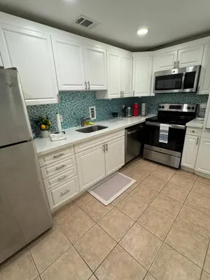 a kitchen with white cabinets and black appliances at Tropical ocean view 1 bedroom in Hollywood