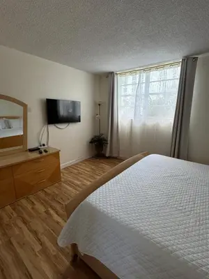 a bedroom with a white bed and a television at Tropical ocean view 1 bedroom in Hollywood