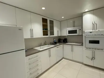 a white kitchen with white cabinets and appliances at Ocean front 1 bedroom in Tropical Paradise in Hollywood