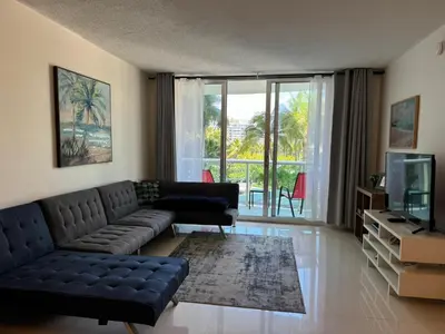 a living room with a couch and a tv at Ocean front 1 bedroom in Tropical Paradise in Hollywood