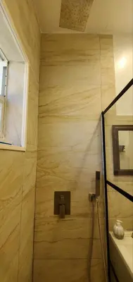 a bathroom with a shower with a sink and a window at Cosy new studio with yard space in Miami in Miami