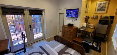 a bedroom with a desk and a dresser and windows at Cosy new studio with yard space in Miami in Miami
