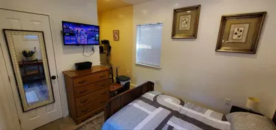 a bedroom with a bed and a dresser and a window at Cosy new studio with yard space in Miami in Miami