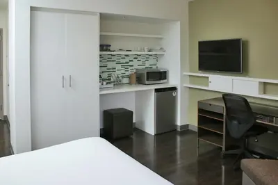 a room with a bed and a desk with a microwave at Element Miami Doral in Miami