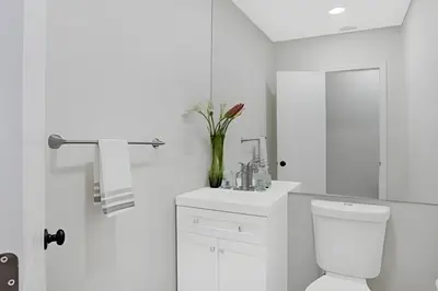 a white bathroom with a toilet and a sink at Luxury Miami Villa in North Miami