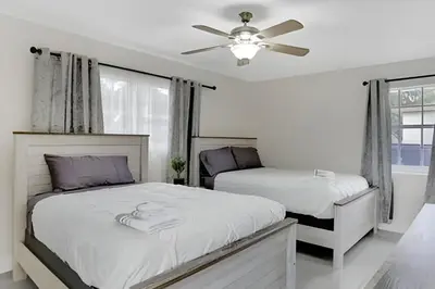 a bedroom with two beds and a ceiling fan at Luxury Miami Villa in North Miami