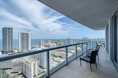 a balcony with two chairs and a view of the city at Million Dollar Penthouse with Pool Amazing Views in Hallandale Beach