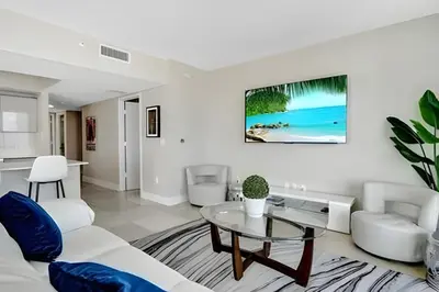 a living room with a white couch and a glass table at Million Dollar Penthouse with Pool Amazing Views in Hallandale Beach
