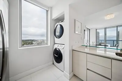 a kitchen with a washer and dryer next to a window at Million Dollar Waterfront Penthouse in Hallandale Beach