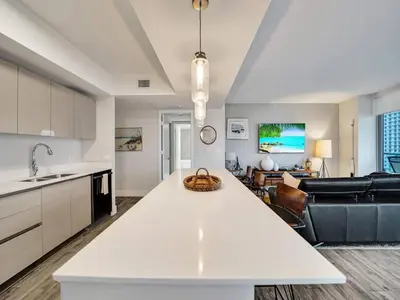 a kitchen and living room with a white counter top at Luxury Waterfront Suite with Great Views in Hallandale Beach
