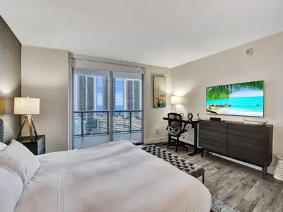 a bedroom with a bed and a flat screen tv at Luxury Waterfront Suite with Great Views in Hallandale Beach