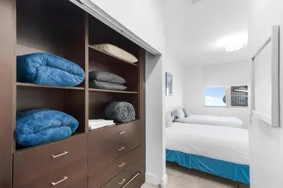 a bedroom with a bed and a book shelf with pillows at Top Floor Luxury Penthouse with Private Roof Deck in Hallandale Beach