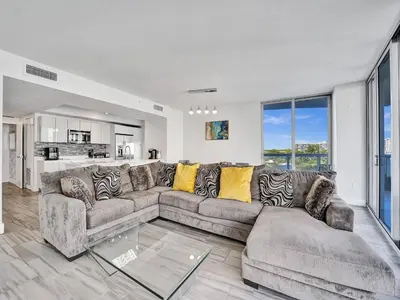 a living room with a couch and a glass table at Luxury Waterfront Suite in Hallandale Beach
