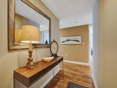 a room with a mirror and a clock on a dresser at Luxury Waterfront Condo in Hallandale Beach
