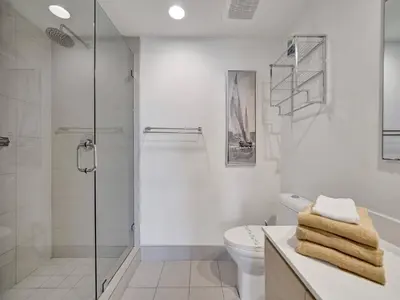 a white bathroom with a shower and a toilet at Luxury Waterfront Condo in Hallandale Beach