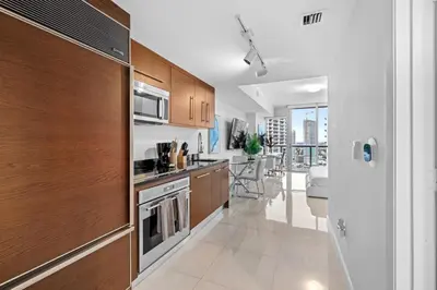 a kitchen with wooden cabinets and a stove top oven at Studio in Miami Brickell Business District ICON Residences in Miami