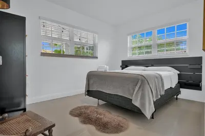 a bedroom with a large bed and two windows at Dolce Vita Hideaway Pool House by Pako Stays in Miami