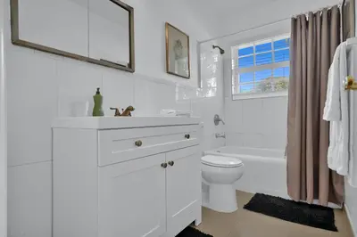 a white bathroom with a sink and a toilet at Dolce Vita Hideaway Pool House by Pako Stays in Miami