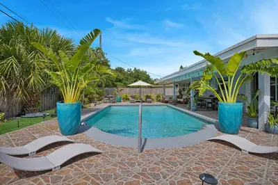 a swimming pool with two chairs and a house at Dolce Vita Hideaway Pool House by Pako Stays in Miami