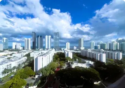 a city with tall buildings and trees in the foreground at Enjoy an endless summer - Parking included! in Sunny Isles Beach