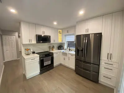 a kitchen with white cabinets and a stainless steel refrigerator at Cozy 2 Bedroom Modern Farmhouse in Miami in Tamiami