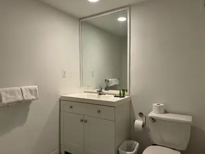 a bathroom with a sink and a toilet and a mirror at 7th FL Ocean view spacious 1 bedroom in Hollywood