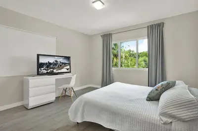 a bedroom with a bed and a desk with a television at Stunning Home LifeStyle Miami in Miami