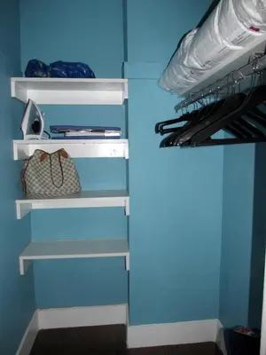 a closet with white shelves and a blue wall at Lux Condo by the Beach in Miami Beach