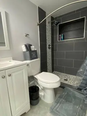 a bathroom with a white toilet and a shower at Annas Peaceful mini Luxury suite in Fort Lauderdale