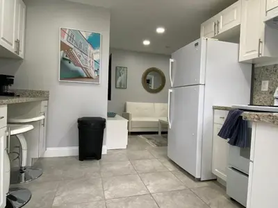 a kitchen with a white refrigerator and a living room at Annas Peaceful mini Luxury suite in Fort Lauderdale