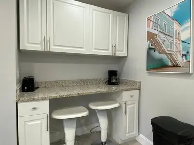 a kitchen with white cabinets and two stools at Annas Peaceful mini Luxury suite in Fort Lauderdale
