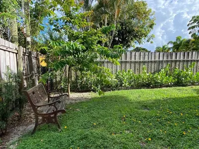 a bench sitting in a yard next to a fence at Annas Peaceful mini Luxury suite in Fort Lauderdale