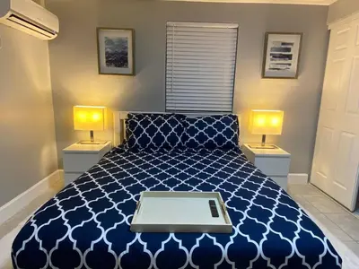 a bedroom with a blue bed with a laptop on it at Executive Luxury Suite in Fort Lauderdale