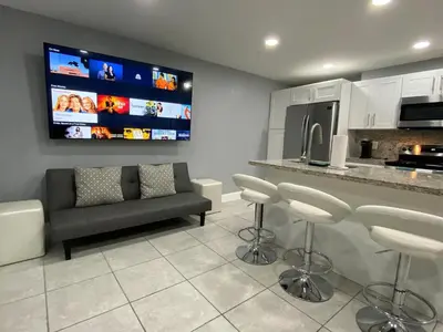 a living room with a couch and a tv at Executive Luxury Suite in Fort Lauderdale